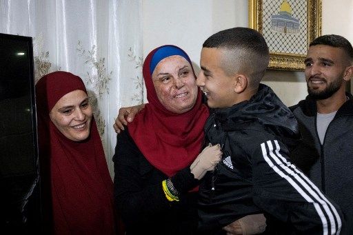 Prominent Palestinian prisoner Israa Jaabis (C) arrives at her home in Israeli-annexed east Jerusalem early on November 26, 2023, after detainees were released from Israeli jails in exchange for hostages released by Hamas from the Gaza Strip. Hamas on November 25, released a second group of Israeli and foreign civilians it had been holding hostage in the Gaza Strip in exchange for Palestinian prisoners, after an hours-long unexpected delay set nerves on edge. Israeli authorities said 13 Israelis and four Thai citizens had returned to Israel. (Photo by Oren ZIV / AFP)