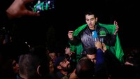Beberapa dari mereka yang dibebaskan mengenakan bendera Palestina, yang lain mengenakan bendera hijau Hamas. Mereka menunjukkan tanda kemenangan saat melakukan crowd-surfing.