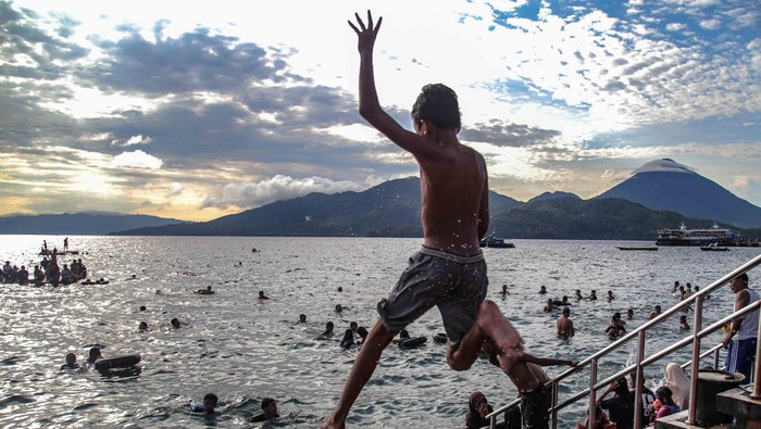 Sejumlah wsiatawan berenang di Pantai Falajawa, Ternate, Maluku Utara, Minggu (26/11/2023). Pantai Falajawa  merupakan daerah reklamasi yang digunakan oleh pemerintah daerah sebagai zona ekonomi untuk menartik kunjungan wisatawan. ANTARA FOTO/Andri Saputra.