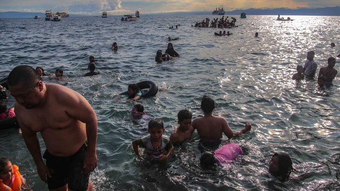 Sejumlah wsiatawan berenang di Pantai Falajawa, Ternate, Maluku Utara, Minggu (26/11/2023). Pantai Falajawa  merupakan daerah reklamasi yang digunakan oleh pemerintah daerah sebagai zona ekonomi untuk menartik kunjungan wisatawan. ANTARA FOTO/Andri Saputra.