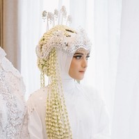 Nadya terlihat mengenakan hijab paris putih yang diikat rapi saat menjadi pengantin Sunda. Dalam foto ini, Nadya memakai wedding robe putih model dres dengan detail tangan berkerut. Ada detail lace dan pearl di bagian lengan. Foto: Dok. Instagram @nadyamustikarahayu.