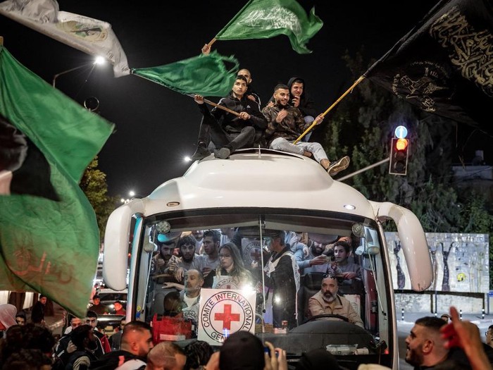 A crowd surrounds a Red Cross bus carrying Palestinians prisoners released from Israeli jails in exchange for hostages released by Hamas from the Gaza Strip, in Ramallah in the occupied West Bank on November 26, 2023. Israels prison service said 39 Palestinian detainees were released on November 26, 2023 under the terms of a truce agreement between Israel and Hamas in the Gaza Strip. The announcement came after 13 Israeli hostages were freed in the Palestinian territory under the deal, along with three Thais and a Russian-Israeli dual citizen. (Photo by Fadel SENNA / AFP)