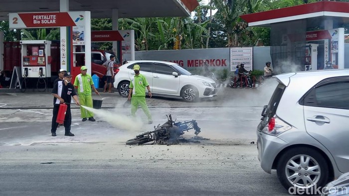 Petugas SPBU Jalan Monjali, Sleman, berusaha memadamkan api yang membakar satu unit sepeda motor, Senin (27/11/2023).