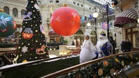 Aktor berpakaian seperti Ded Moroz, Kakek Frost, Sinterklas Rusia dan Snegurochka, Snow Maiden berjalan di dalam department store GUM, yang didekorasi untuk perayaan Natal dan Tahun Baru.  