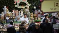Seorang pelayan toko tengah melayani pengunjung yang berbelanja permen dan cokelat untuk merayakan Natal.  