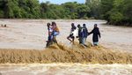 Potret Warga Kenya Nekat Seberangi Sungai yang Meluap