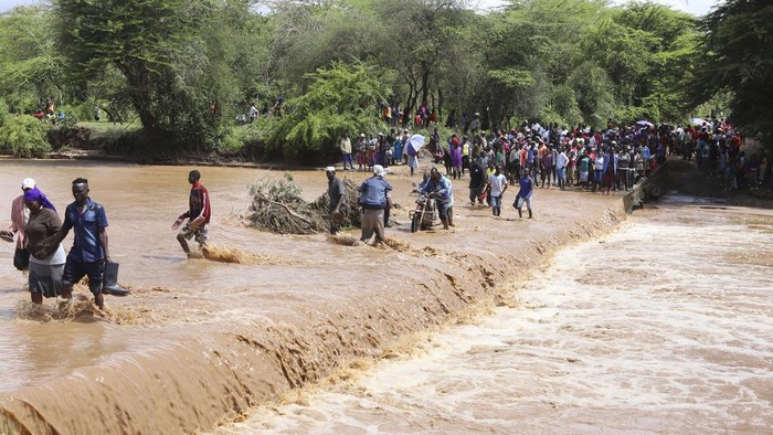 Potret Warga Kenya Nekat Seberangi Sungai yang Meluap People cross through a flooded Muuoni River, where 8 people are said to have drowned overnight while crossing the river at Mukaa area, Makueni county, Eastern Kenya, Friday Nov. 24, 2023. Flood-related death toll is going higher everyday as heavy rains continue to pound across East Africa. (AP Photo )