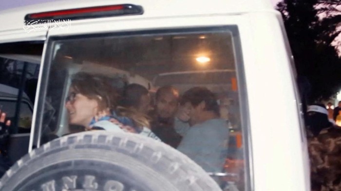 Hostages who were abducted by Hamas gunmen during the October 7 attack on Israel, are handed over by Hamas militants to members of the International Committee of the Red Cross, as part of a hostages-prisoners swap deal between Hamas and Israel amid a temporary truce, in an unknown location in the Gaza Strip, in this screengrab taken from video released November 26, 2023. Hamas Military Wing/Handout via REUTERS THIS IMAGE HAS BEEN SUPPLIED BY A THIRD PARTY WATERMARK FROM SOURCE.