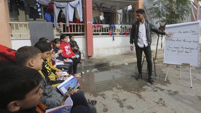 English teacher Tariq Al-Annabi holds a class in a UN-run school in Rafah, Gaza Strip, on Sunday, Nov. 26, 2023, on the third day of a temporary ceasefire between Hamas and Israel. (AP Photo/Hatem Ali)