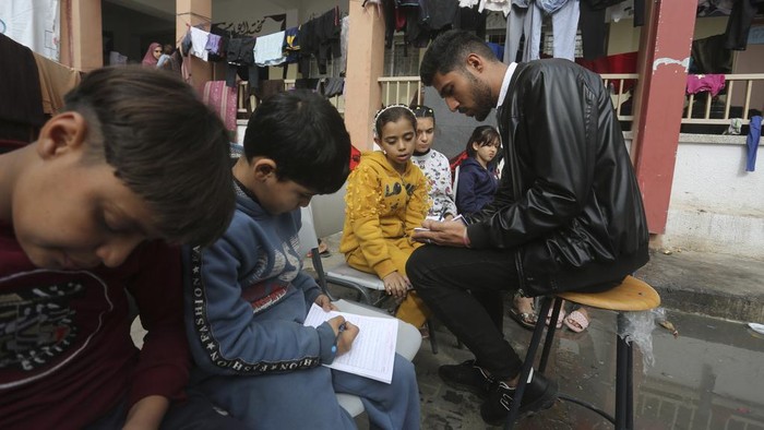 English teacher Tariq Al-Annabi holds a class in a UN-run school in Rafah, Gaza Strip, on Sunday, Nov. 26, 2023, on the third day of a temporary ceasefire between Hamas and Israel. (AP Photo/Hatem Ali)