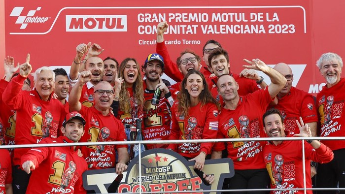 Semringah Francesco Bagnaia Pertahankan Gelar Juara Dunia MotoGP Italian rider Francesco Bagnaia of the Ducati Lenovo Team, center, poses with his team after the MotoGP race of the Valencia Motorcycle Grand Prix, the last race of the season, at the Ricardo Tormo circuit in Cheste near Valencia, Spain, Sunday, Nov. 26, 2023. (AP Photo/Alberto Saiz)