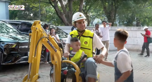 Datang bersama kedua putranya, Raffi Ahmad dan Cipung tampak menaiki excavator mini berwarna kuning, sementara Rafathar berjalan di sebelahnya. Nagita sendiri sudah terlebih dulu sampai dengan menaiki mobil hitamnya. Foto: YouTube/Rans Entertainment