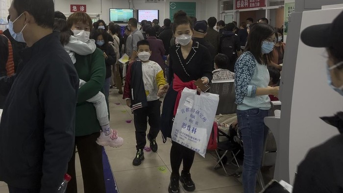 Parents with their children wait at a crowded holding room of a children's hospital in Beijing on Oct. 30, 2023. A surge in respiratory illnesses across China that has drawn the attention of the World Health Organization is caused by the flu and other known pathogens and not by a novel virus, the country's health ministry said Sunday, Nov. 26, 2023. (AP Photo/Andy Wong)