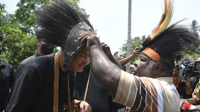 Potret Kampanye Perdana Ganjar di Papua Calon presiden nomor urut tiga Ganjar Pranowo (kanan) menyanyikan lagu Padamu Negeri saat melakukan kampanye perdana di Distrik Semangga, Merauke, Papua Selatan, Selasa (28/11/2023). Dalam tatap muka itu, Ganjar Pranowo menemui warga dusun Waninggap Nango, Matara dan Urumb dengan mencanangkan program satu desa satu puskesmas. ANTARA FOTO/M Risyal Hidayat/aww.