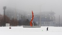 Seseorang menarik kereta luncur bersama seorang anak di dekat kantor baru Yandex yang sedang dibangun setelah hujan salju lebat di Moskow, Rusia, Senin (27/11/2023). REUTERS/Maxim Shemetov