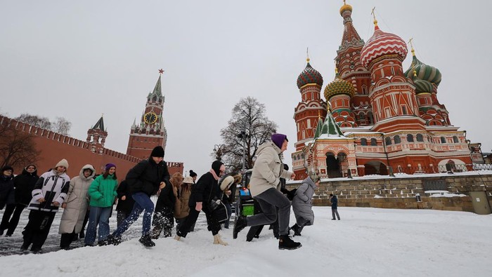 People walk across a snowbank near the Kremlin wall and St. Basils Cathedral following a heavy snowfall in Moscow, Russia, November 27, 2023. REUTERS/Evgenia Novozhenina