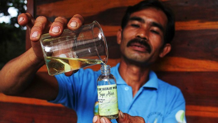 Ketua Kelompok Tani Fajar Atsiri Ade Maryadi menuangkan minyak serai hasil penyulingan ke dalam botol untuk dijual di kediamannya Dusun Sinar Timur, Desa Penjalaan, Kecamatan Simpang Hilir, Kabupaten Kayong Utara, Kalimantan Barat, Senin (27/11/2023). Badan Restorasi Gambut dan Mangrove (BRGM) melakukan pendampingan pemanfaatan gambut secara bijak kepada Kelompok Tani Fajar Atsiri di Kabupaten Kayong Utara yang memproduksi minyak serai wangi, karbol, aroma terapi, lilin dan minyak urut Bang Gosok dengan memberikan peralatan kerja, dana pengembangan usaha dan rangkaian pelatihan untuk menambah keterampilan.