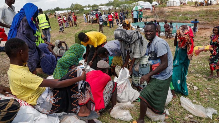 89.000 Keluarga Mengungsi dan 120 Orang Tewas Akibat Banjir Kenya People displaced by flood waters receive relief aid near their makeshift camp following heavy rains in Garsen, Tana Delta within Tana River county, Kenya November 23, 2023. REUTERS/Thomas Mukoya