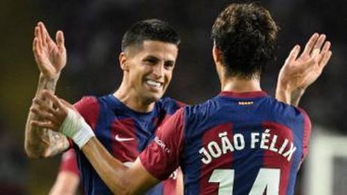 Barcelonas Portuguese forward #14 Joao Felix celebrates with Barcelonas Portuguese defender #02 Joao Cancelo after scoring his teams first goal during the Spanish Liga football match between FC Barcelona and Real Betis at the Estadi Olimpic Lluis Companys in Barcelona on September 16, 2023. (Photo by Josep LAGO / AFP)