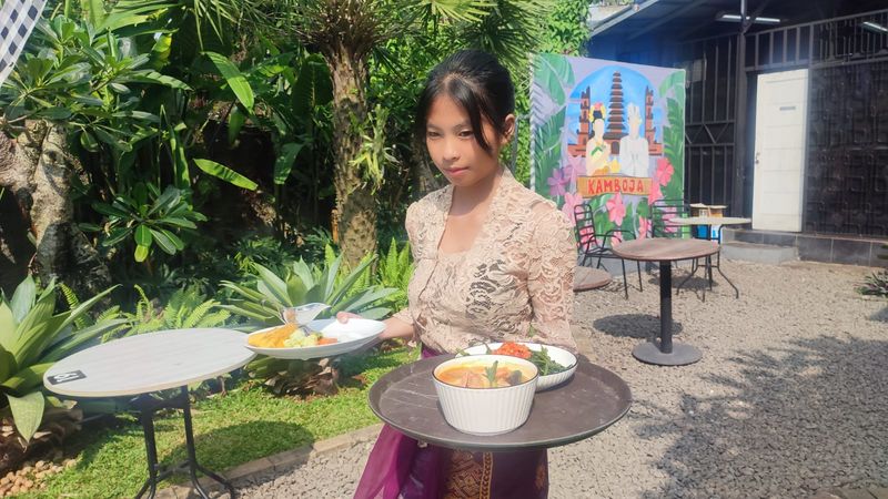 Pelayan di kafe dan resto Kamboja Green House siap mengantar menu yang dipesan pengunjung