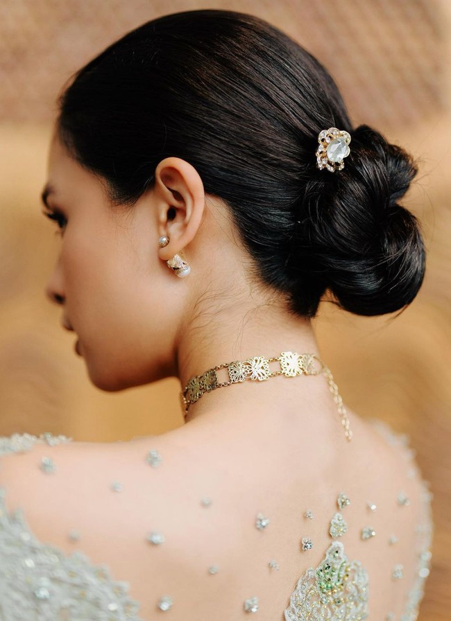 Untuk rambut istri Jesse Choi itu memilih tampil simpel namun tetap rapi dengan rambut yang dicepol ke belakang. Bagian cepol rambutnya pun dipercantik dengan aksesori tusuk konde berbentuk bunga dengan warna emas. Foto: Instagram/@maudyayunda