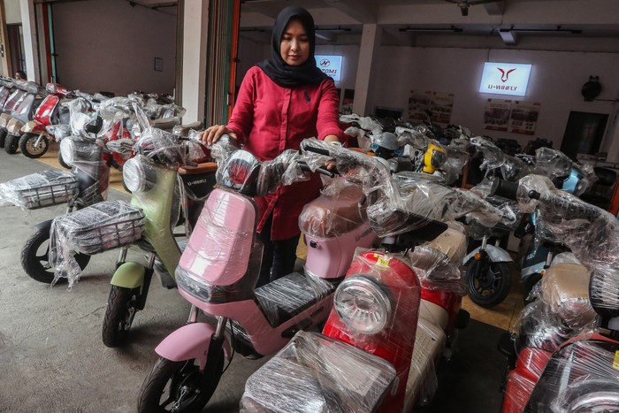 Pramuniaga merapikan kendaraan motor listrik yang dijual di sebuah diler di kawasan Jalan Fatmawati, Semarang, Jawa Tengah, Rabu (29/11/2023). Pemerintah menargetkan pada tahun 2025 populasi kendaraan listrik roda dua dan tiga secara nasional bisa mencapai 6 juta unit dan jumlah tersebut diharapkan terus meningkat hingga 12 juta unit pada tahun 2035, sehingga Indonesia bisa menghemat penggunaan BBM sebanyak 18,86 juta barrel atau setara 6,9 juta ton karbon dioksida. ANTARA FOTO/Makna Zaezar/Spt.