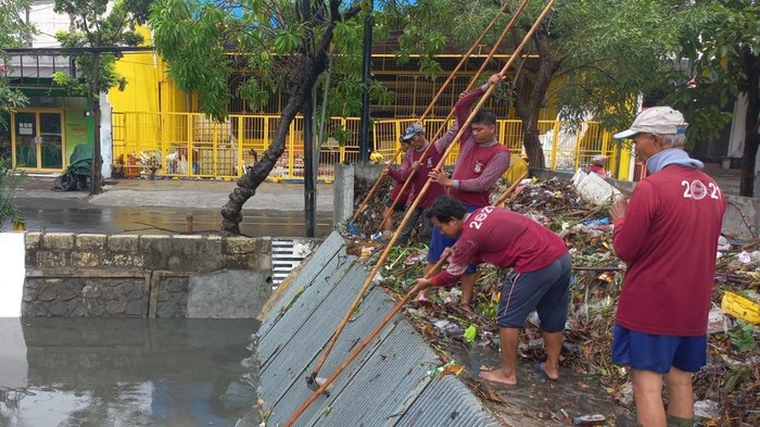 Sampah yang menumpuk di mechanical screen rumah pompa hingga menyebabkan genangan saat Surabaya diguyur hujan.