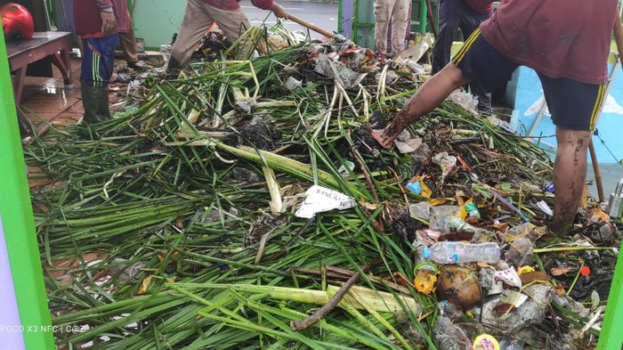 Sampah yang menumpuk di mechanical screen rumah pompa hingga menyebabkan genangan saat Surabaya diguyur hujan.