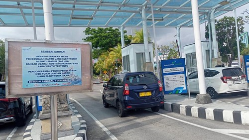 Papan pengumuman penerapan parkir nontunai di pintu masuk Bandara I Gusti Ngurah Rai, Bali, Selasa (28/11/2023).