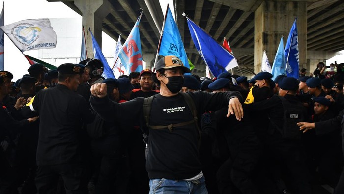 Aksi buruh Kabupaten Bekasi Sejumlah personel Kepolisian menahan buruh yang ingin menuju gerbang Tol Cibitung 3 di kawasan MM 2100, Kabupaten Bekasi, Jawa Barat, Kamis (30/11/2023). Mereka menuntut penetapan UMK (Upah Minimum Kabupaten/Kota) Bekasi sebesar 15 persen pada tahun 2024. ANTARA FOTO/ Fakhri Hermansyah/rwa.