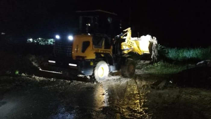 Alat berat membersihkan material longsor di Desa Parsaoran Nainggolan, Kecamatan Pahae Jae, Kabupaten Tapanuli Utara. (Dok Polres Taput)