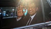 Anies melambaikan tangan sambil tersenyum dari dalam mobil yang akan membawanya meninggalkan GBI Mawar Sharon.  