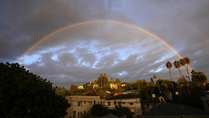 Visitors take selfies with a double rainbow at the Griffith Observatory in Los Angeles, Wednesday, Nov. 29, 2023. (AP Photo/Jae C. Hong)