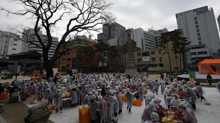 Buddhist monks and Buddhists make kimchi, a staple Korean side dish, at Jogye temple in Seoul, South Korea, Wednesday, Nov. 29, 2023. They will donate about 3,000 packets of kimchi to needy neighbors in preparation for the winter season. (AP Photo/Lee Jin-man)