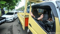 Beberapa sopir nampak keluar dari mobil, sementara sopir lainnya nampak tertidur di mobil. 
