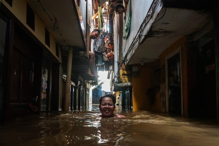 Seorang warga menerobos banjir yang merendam rumah di kawasan Kebon Pala, Kampung Melayu, Jakarta, Kamis (30/11/2023). Menurut data Badan Penanggulangan Bencana Daerah (BPBD) Provinsi DKI Jakarta pada pukul 15:00 WIB total wilayah yang tergenang sebanyak 57 RT akibat curah hujan tinggi dan luapan Kali Ciliwung. ANTARA FOTO/Rifqi Raihan Firdaus/nz