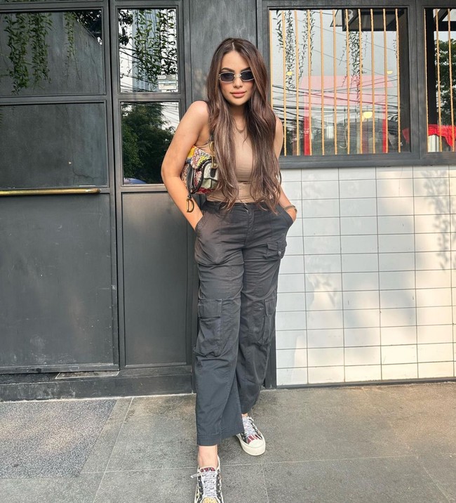 Simple minimalis, aura ladyboss tetap terpancar saat Sarah Ahmad mengenakan atasan tanpa lengan dan celana cargo bernyansa earthy. Kacamata hitam, sneakers plus clutch melengkapi penampilannya. Foto: Instagram/@saraaaahmad