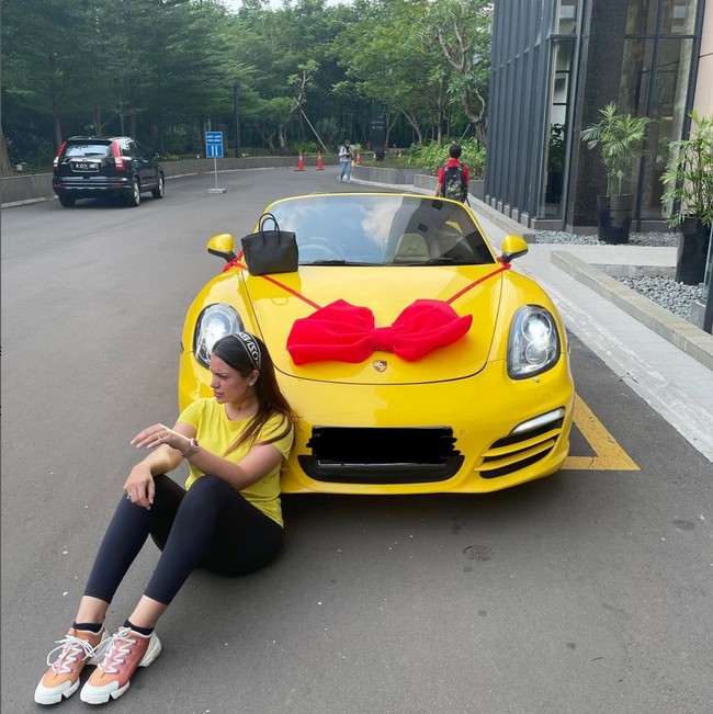 Sarah Ahmad beberapa kali berpose dengan mobil-mobil mewah miliknya. Dalam salah satu foto, dia bahkan tampil serasi dengan mobil Porsche berwarna kuning.  Foto: Instagram/@saraaaahmad