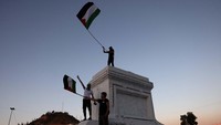 Dalam peringatan ini, warga mengibarkan bendera Palestina. 