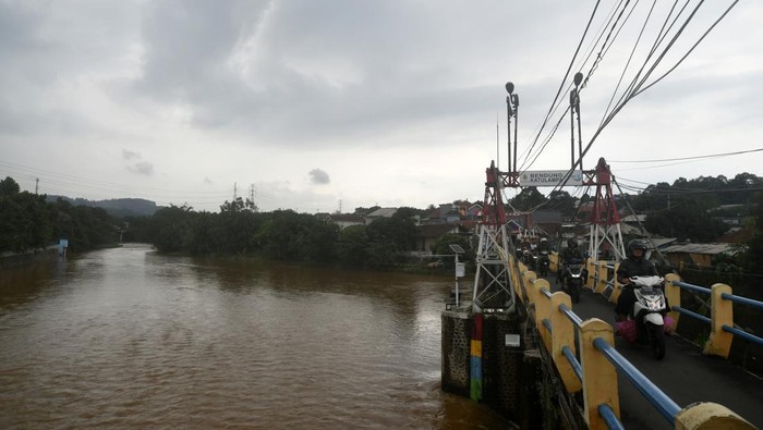 Sejumlah pengendara motor melintas di jembatan Bendung Katulampa dengan Tinggi Muka Air (TMA) mencapai 30 sentimeter di Kota Bogor, Jawa Barat, Kamis (30/11/2023). Hujan deras di wilayah Bogor dan sekitarnya menyebabkan TMA Bendung Katulampa, Bogor naik mencapai angka 160 sentimeter dengan status siaga dua pada Rabu (29/11/2023) malam pukul 20:15 WIB. ANTARA FOTO/Arif Firmansyah/rwa.