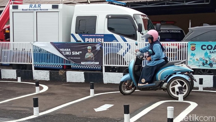 Titin (47) saat mengikuti ujian praktik dan menerima SIM D di Mapolresta Cirebon