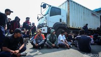 Massa dari berbagai elemen buruh lantas kembali menutup jalan dengan cara duduk bersama. 