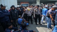 Aksi tersebut sempat ditenangkan oleh petugas Kepolisian yang meminta buruh agar tidak membahayakan diri. 