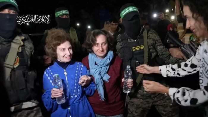 An image grab from a handout video released by the Hamas Media Office shows Hamas fighters handing over newly released Israeli-Russian hostages to the Red Cross, in the Gaza Strip on November 29, 2023. Two hostages with Russian citizenship released by Hamas in the Gaza Strip on November 29 arrived in Egypt via the Rafah crossing, state television Al-Qahera News reported. (Photo by HAMAS MEDIA OFFICE / AFP) / XGTY / NO ARCHIVES == RESTRICTED TO EDITORIAL USE - MANDATORY CREDIT 