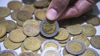 Warga menunjukkan uang logam pecahan Rp 1.000 dan Rp 500 di Jakarta, Jumat (1/12/2023).