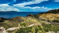 Wisatawan menikmati pemandangan dari Bukit Savana Pulisan. Bukit Pulisan terletak di Likupang Timur, Kabupaten Minahasa Utara, Sulawesi Utara. Butuh waktu tempuh sekitar 2 jam dari Manado.