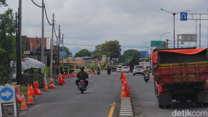 Progres pelebaran jalan dan pengaspalan Ring Road Utara di simpang empat Kronggahan yang terdampak tol Jogja-Solo, Jumat (1/12/2023)