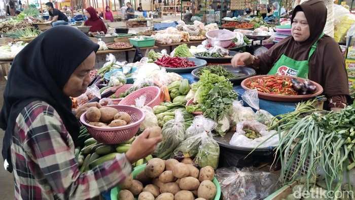 Yuyun pedagang di Pasar Baru Kuningan sedang melayani pembeli
