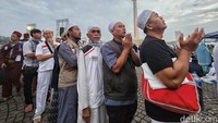 Beberapa sambil berdoa mengikuti doa yang terdengar dari pengeras suara sambil mengantre. 
