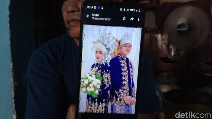 Paman Junita menunjukkan foto prewedding Junita dan Suparman.